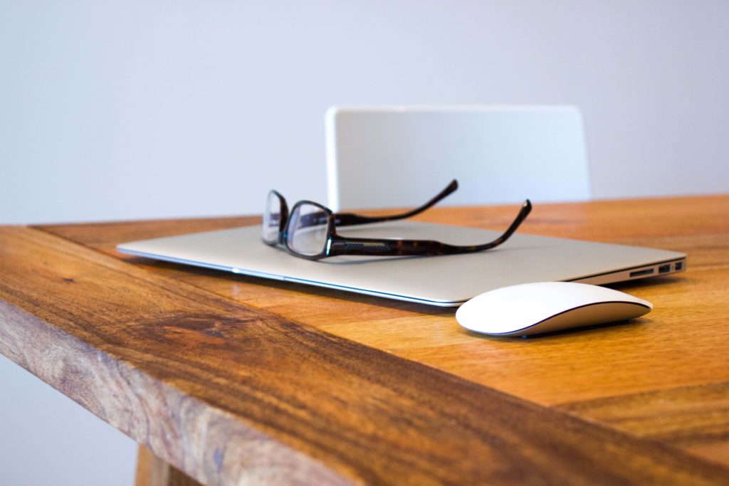 laptop on desk with glasses