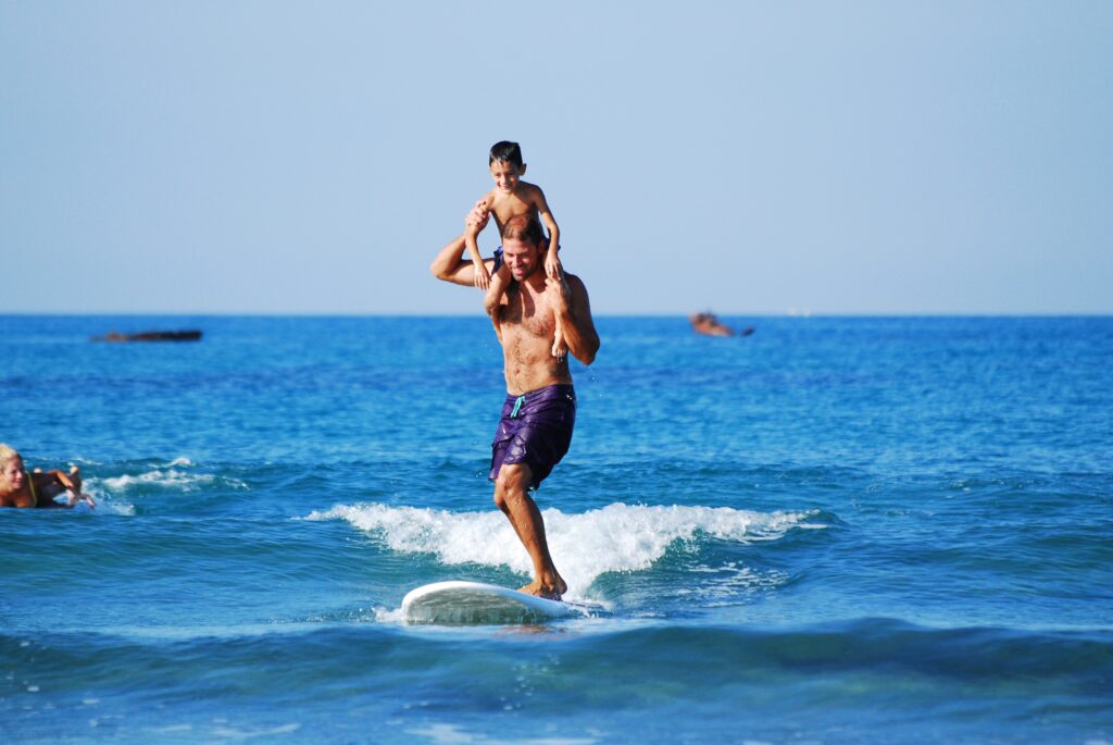 father surfing with son