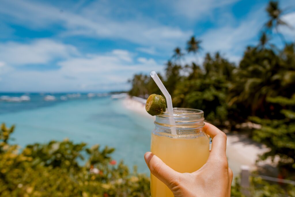 holding cocktails on a beach loa
